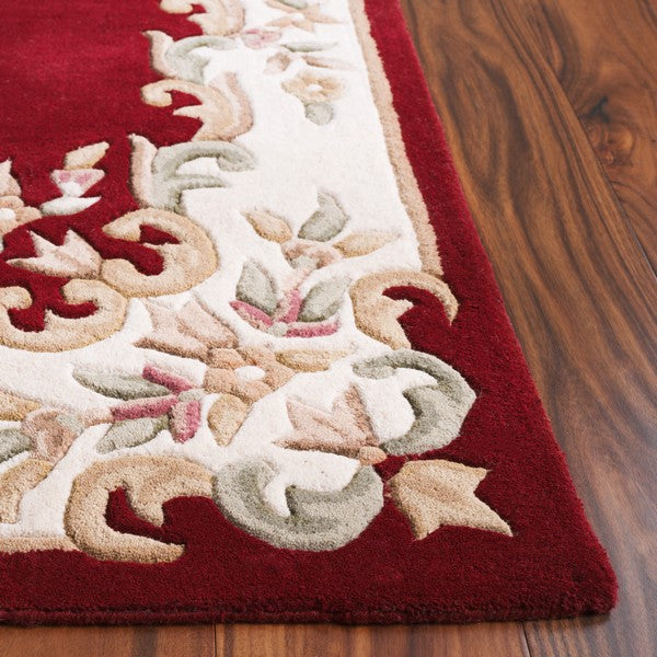 Close-up of ivory floral border with beige sage and blush details on Aurelia wool rug